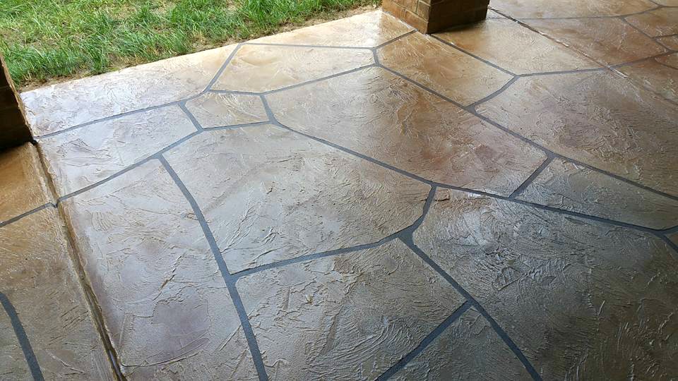 Grand Flagstone covered patio in tan and brown hand-tooled stones with dark charcoal grout joints