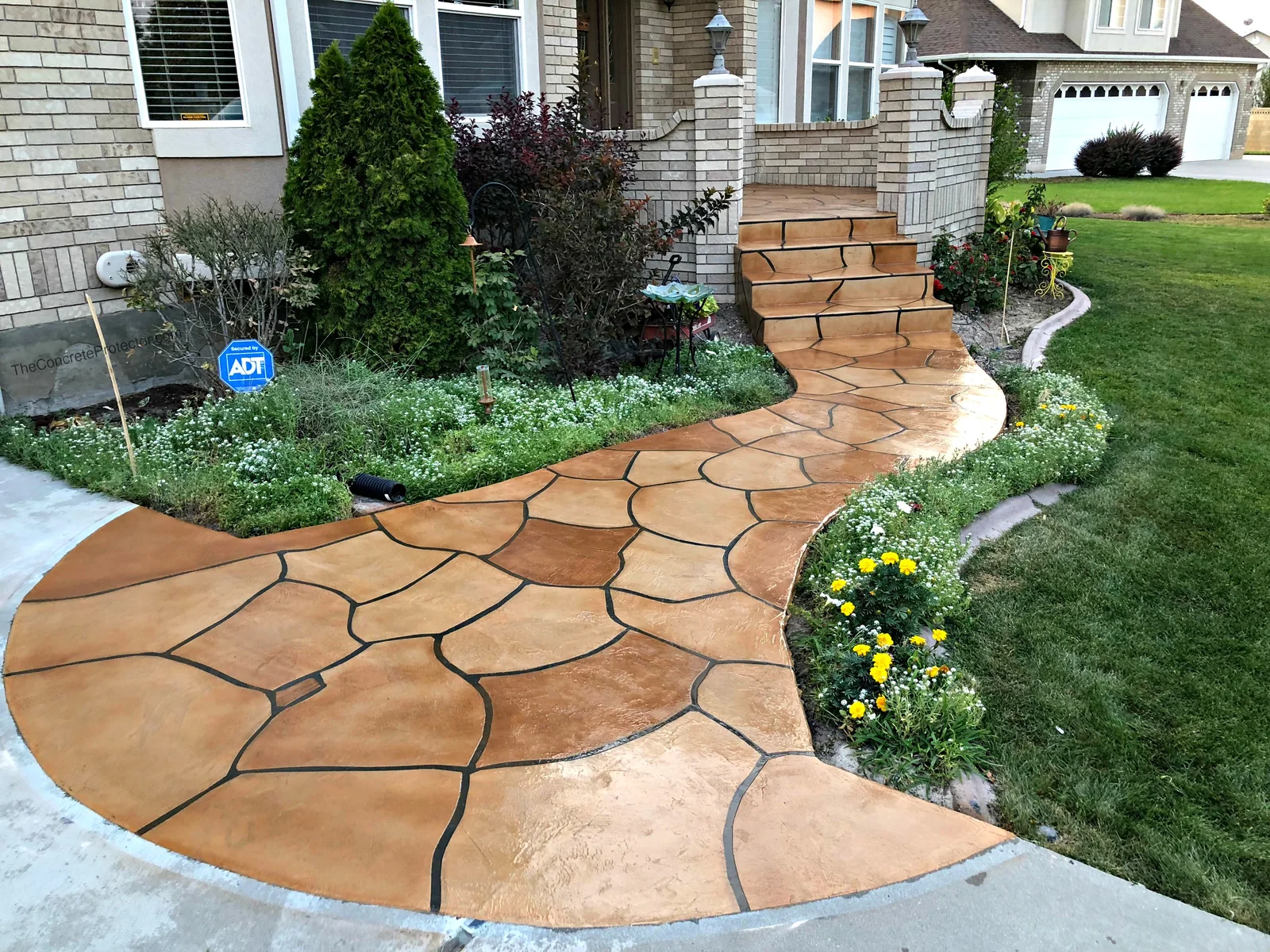 Grand Flagstone walkway curving through landscaping to a home's front steps