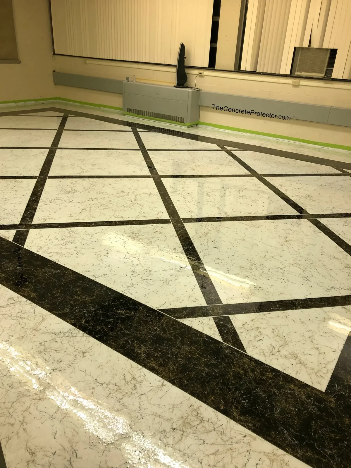 Italian Marble floor laid out in a white marble grid with dark banding, freshly coated in a taped-off room