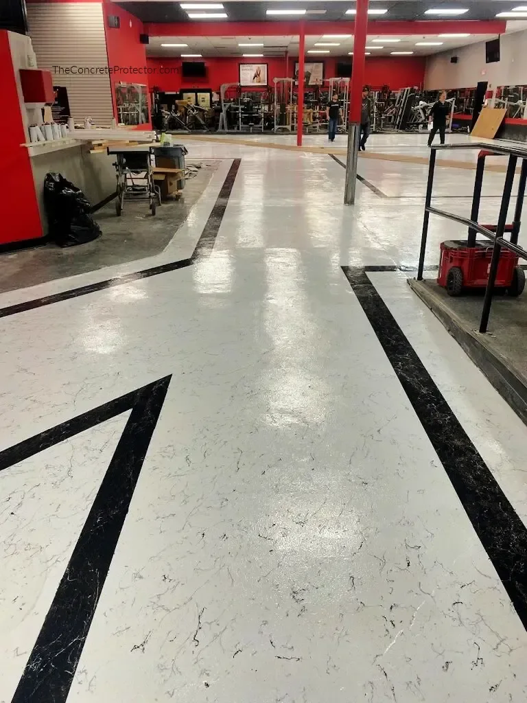 Italian Marble floor running through a fitness center with black marble border bands