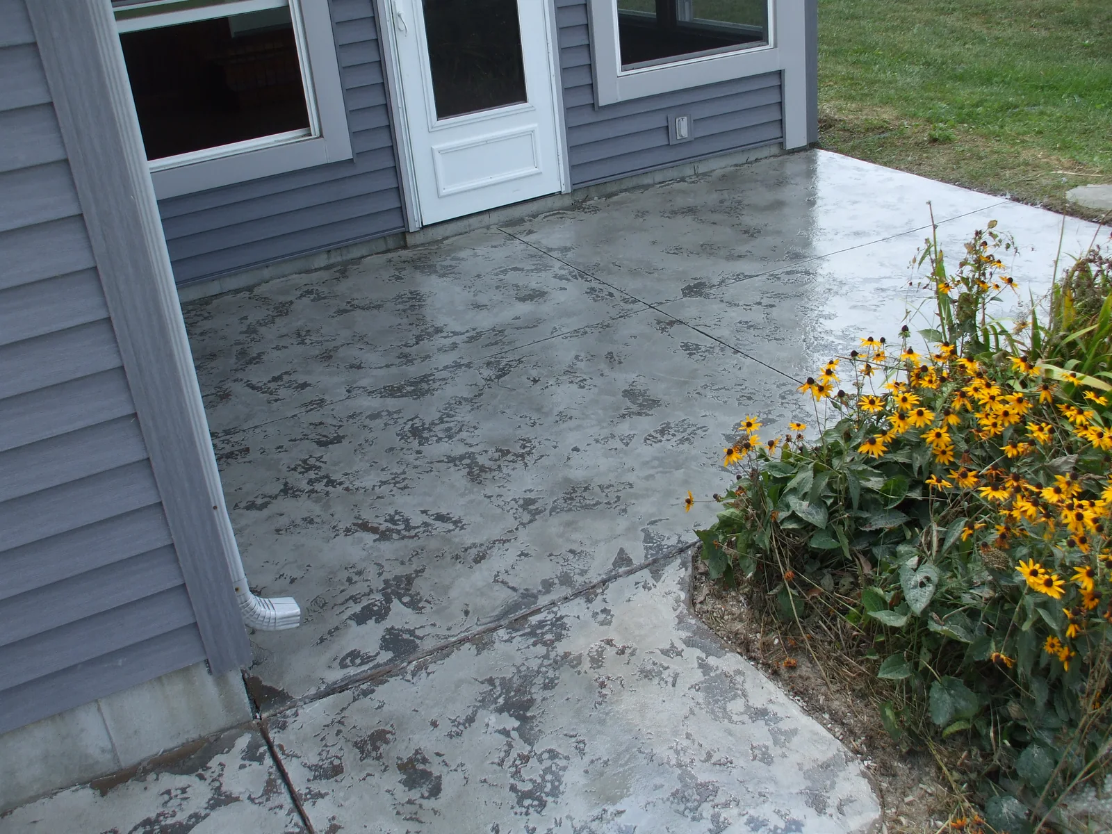 Tuscan Slate patio troweled in soft grey, running out to the flower beds